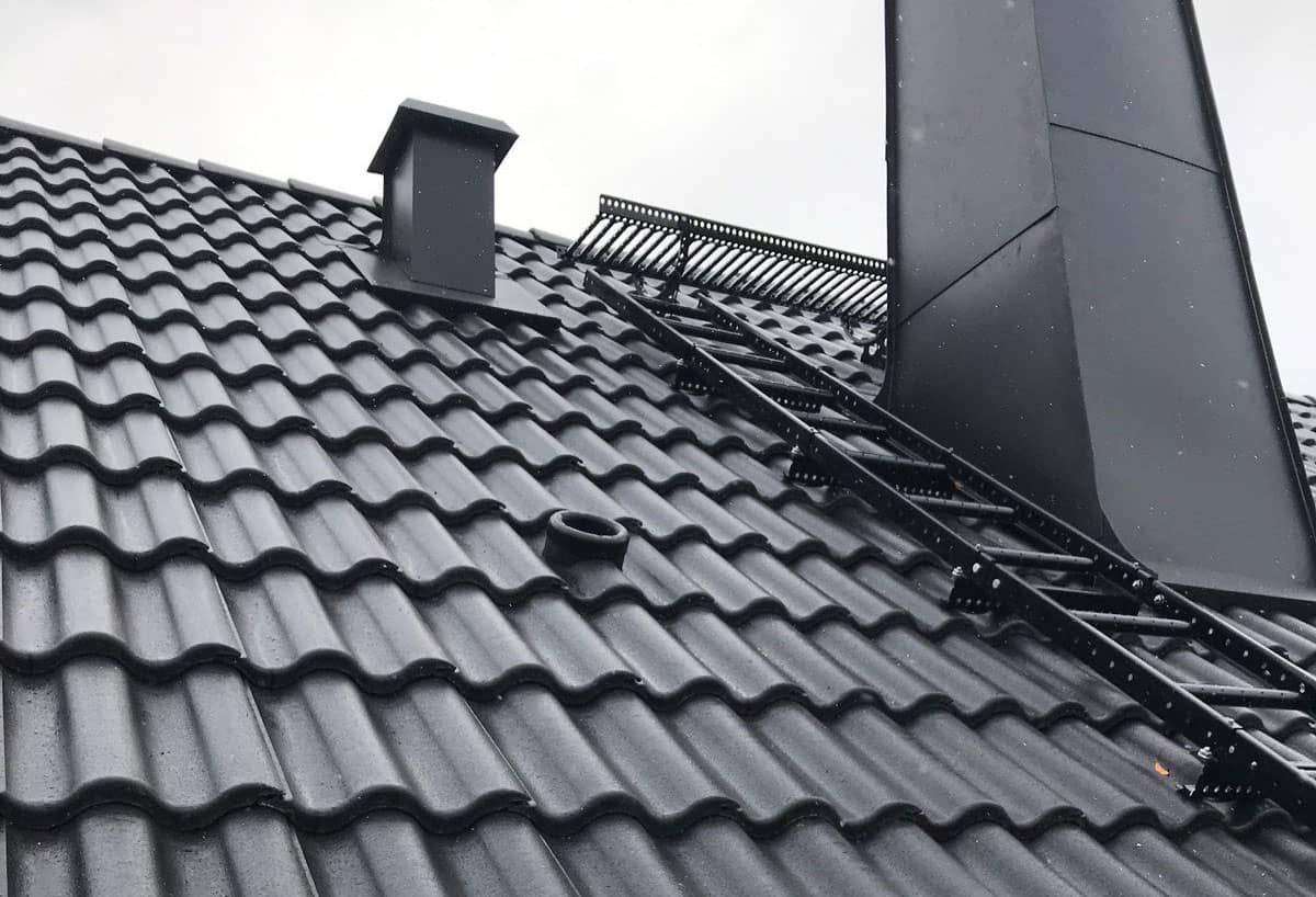 Takläggare inspekterar ett panntak efter takläcka