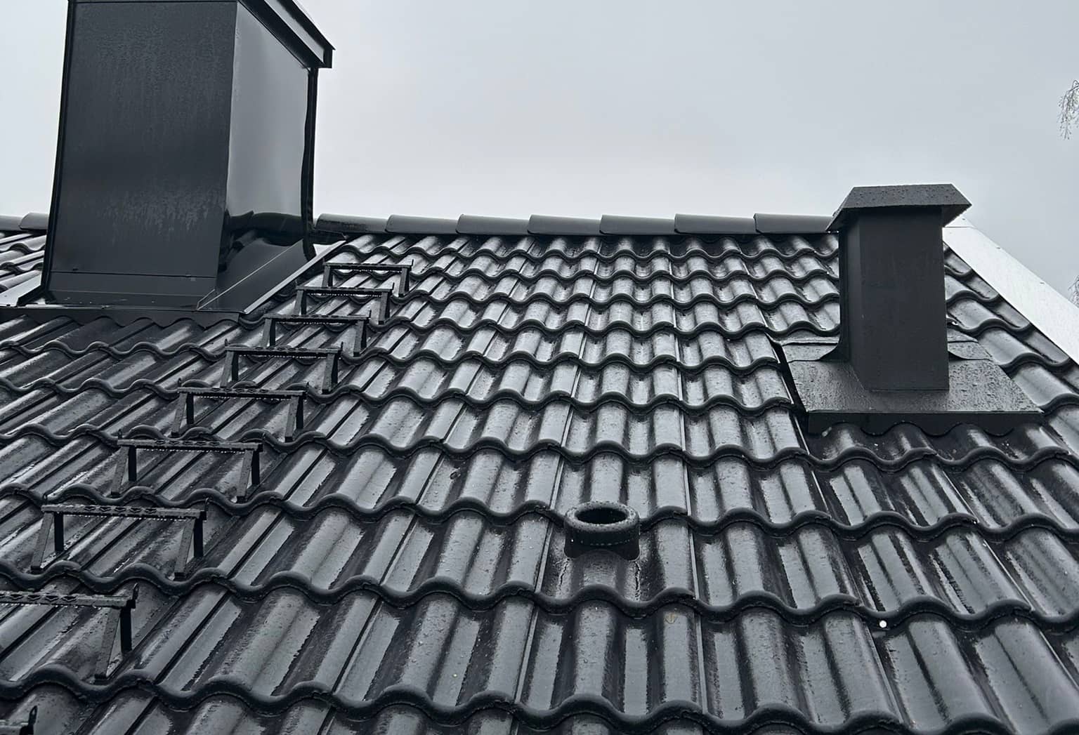 Takläggare lägger mörka betongpannor på villatak